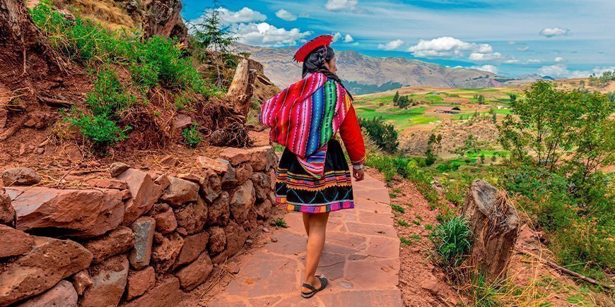 Inheemse vrouw loopt langs een Inca-muur in Cusco in oktober