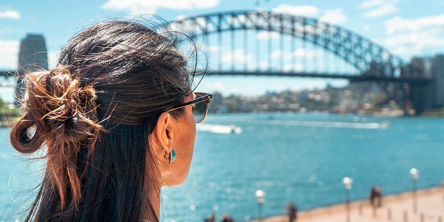Vrouw kijkt naar de Sydney Harbour Bridge in Sydney, Australië