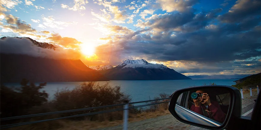 Man neemt foto vanuit het raam bij Lake Wakatipu op het Zuidereiland in Nieuw-Zeeland