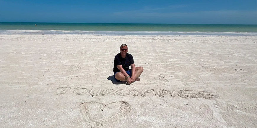 Tom zit in het zand op Isla Holbox in Mexico